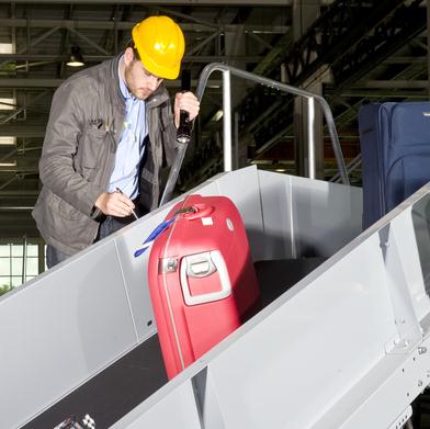 Ingénieur inspectant le convoyeur de bagages